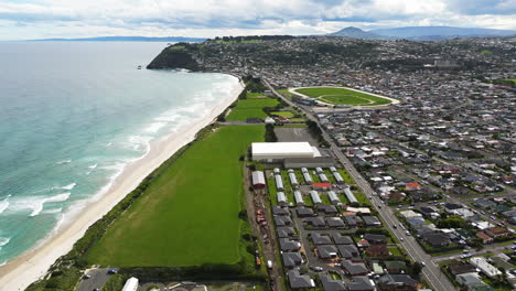 Edificios-De-La-Ciudad-De-Dunedin-Y-Estadio-En-La-Costa-Del-Océano-Pacífico,-Vista-Aérea-De-Drones