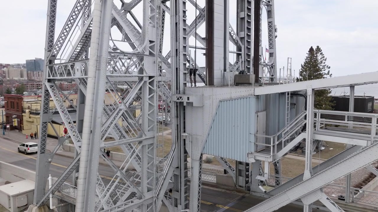 Steel towers and cables of aerial lift bridge in Duluth, Minnesota as cars drive across shipping canal