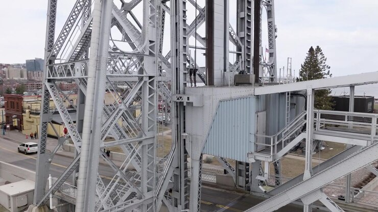 Steel towers and cables of aerial lift bridge in Duluth, Minnesota as cars drive across shipping canal