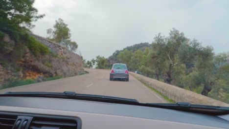 a drive in sant llorenç road showing traditional mallorcan village greenery, following a car mallorca, spain