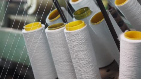 Close-up of textile bobbins on a machine