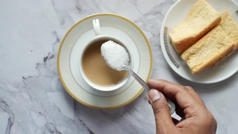 Draufsicht-Auf-Das-Einfüllen-Von-Zucker-In-Eine-Teetasse