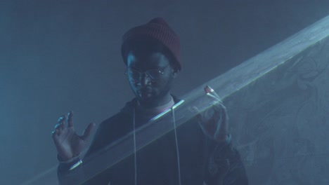 afro man dancing in dark room with laser light projection