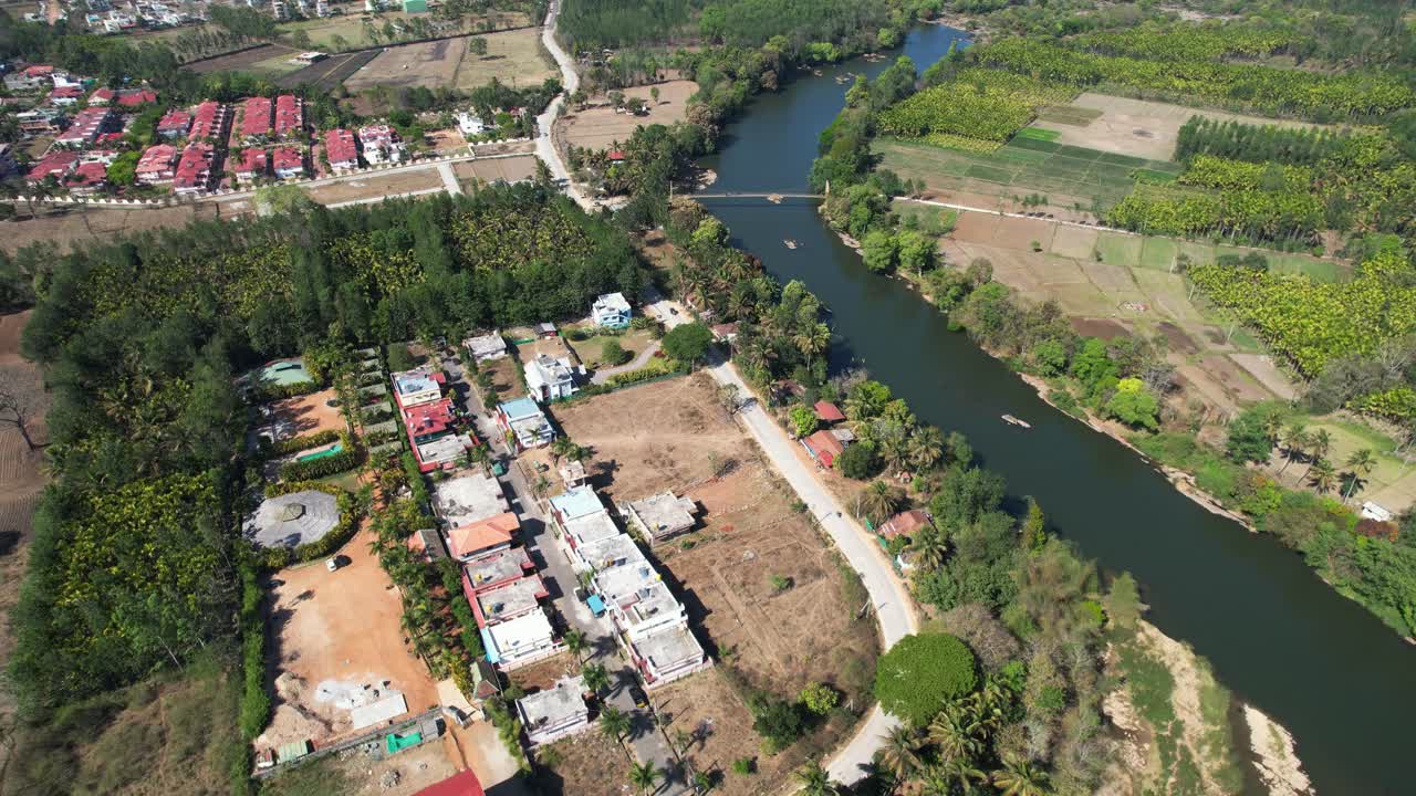 An aerial view over a river reveals a stunning road and riverfront houses