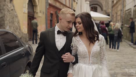 newlyweds, caucasian groom with bride walking, embracing, hugs in city, wedding couple in love