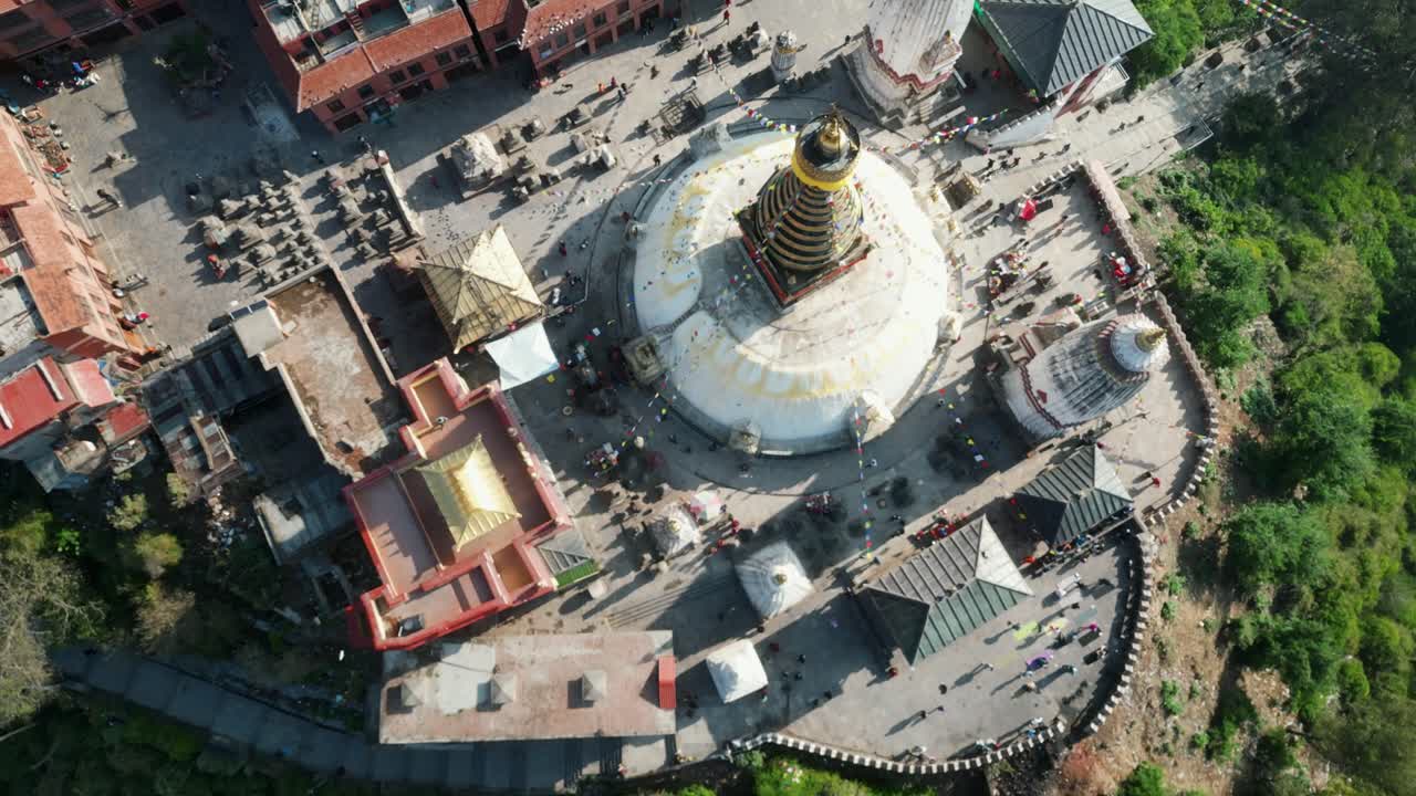 Aerial view over Swayambhunath temple, ancient buddhist shrine, with prayer flags moving in the wind, Kathmandu, Nepal