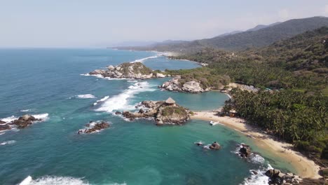 4k aerial pan shot of sea and rock tropical tayrona park cabo san juan colombia