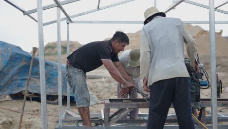 construction workers installing engine on metal frame structure