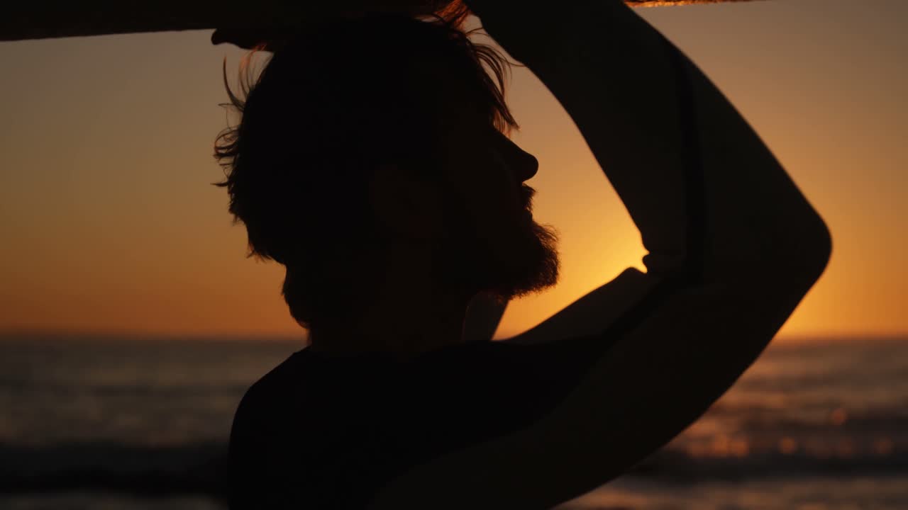 ビーチ4kでサーフボードで歩いている男性