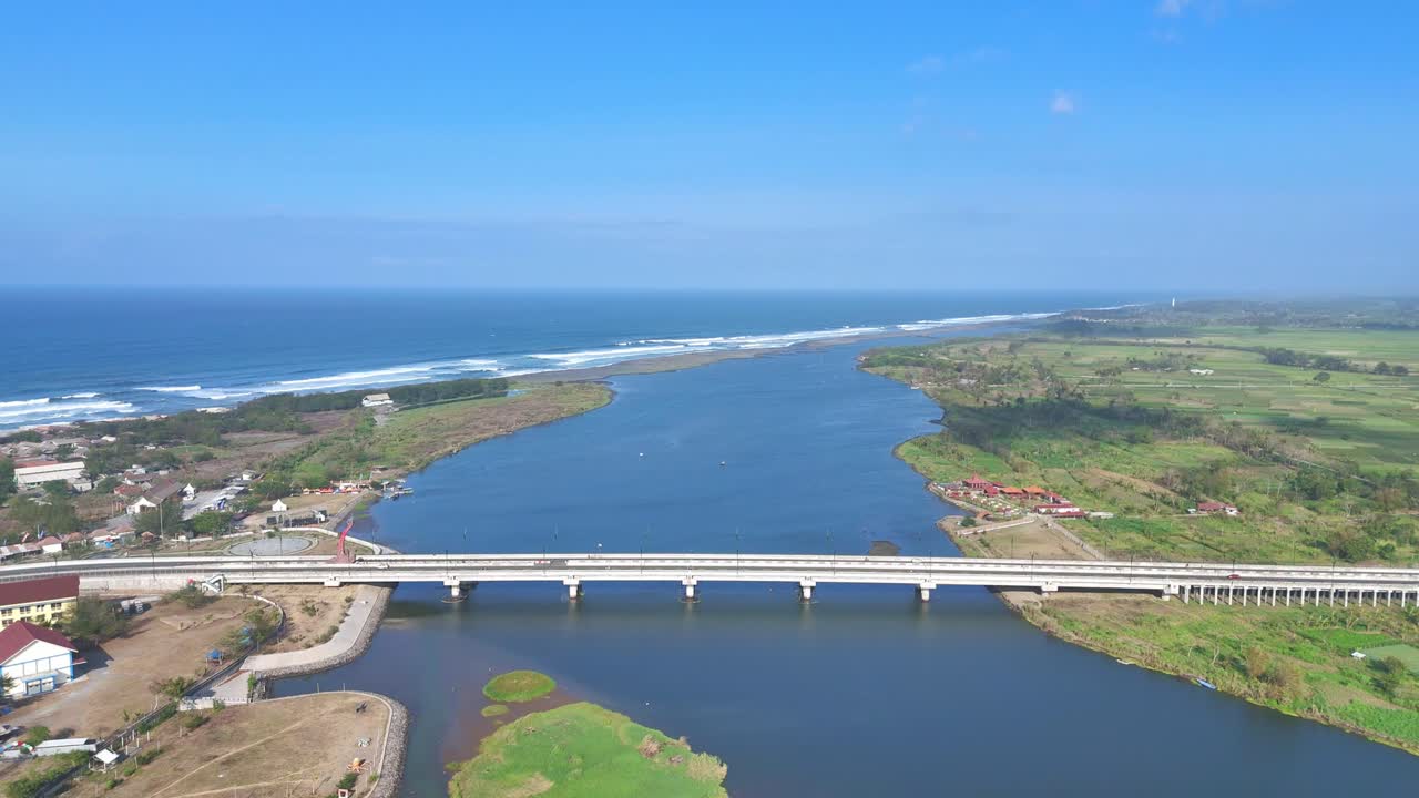 Aerial view of a white bridge on the river mouth to the beach. 4K drone shot.
