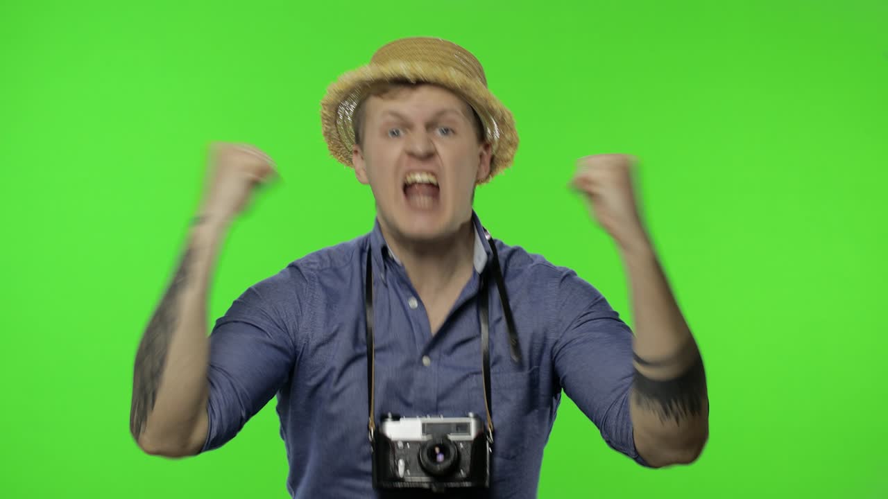 젊은 남자 관광 사진작가의 초상화는 불만을 느끼고 화를 내고 있습니다.