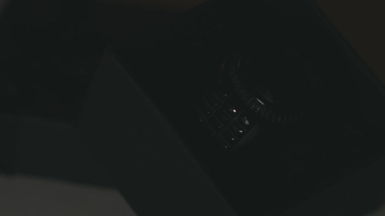 Glimpse Of Light Moving Around The Luxury Silver Men's Ring With Black Gemstone On A Black Box. - close up shot