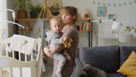 mom standing with baby son in kids room
