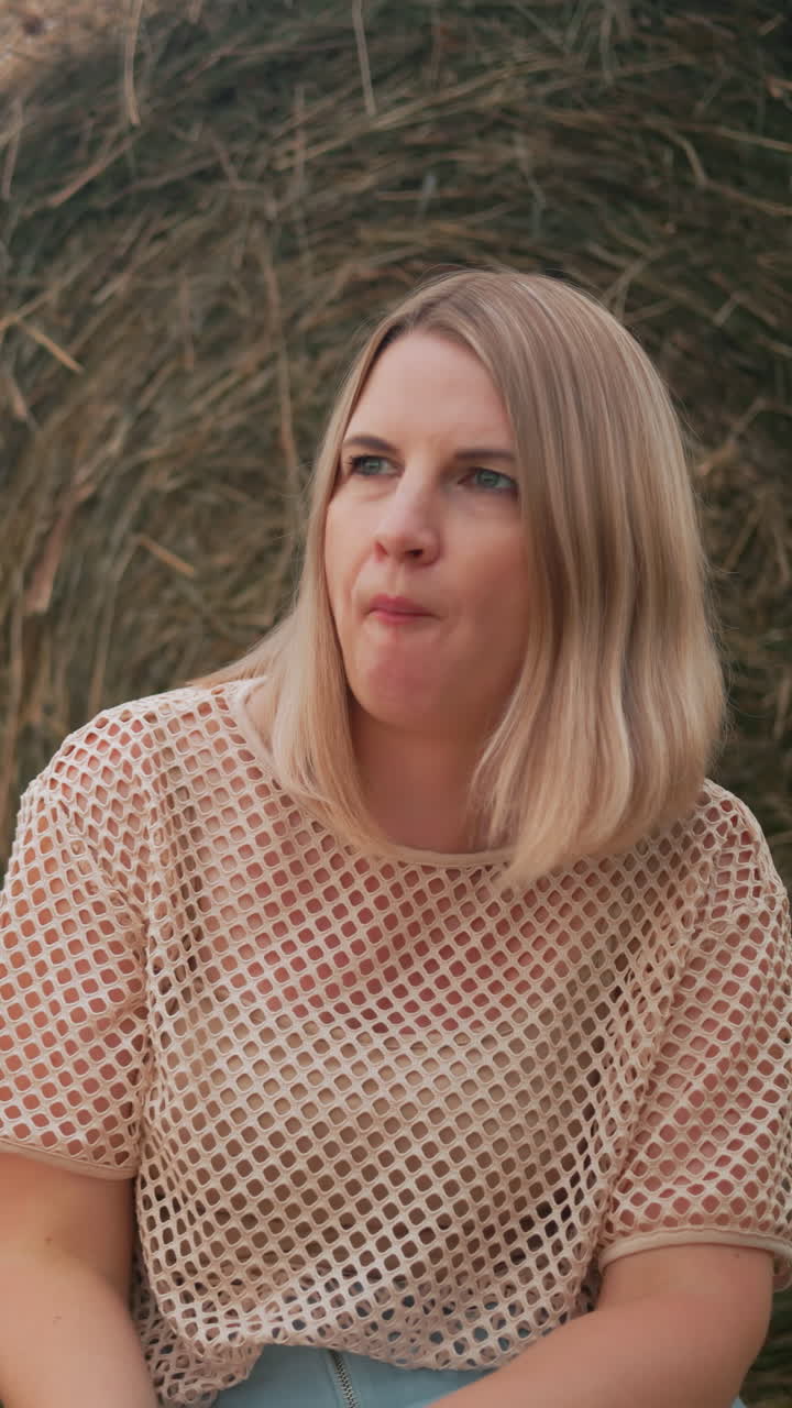 네트 을 입은 젊은 여성이 그녀의 친구가 즐기는 동안 그녀의 한 페이스트리를 맛보며, 뒷면에  어리가 있는 열린 에서 풀 위에 앉아 평화로운 야외 순간을 즐기고 있습니다.