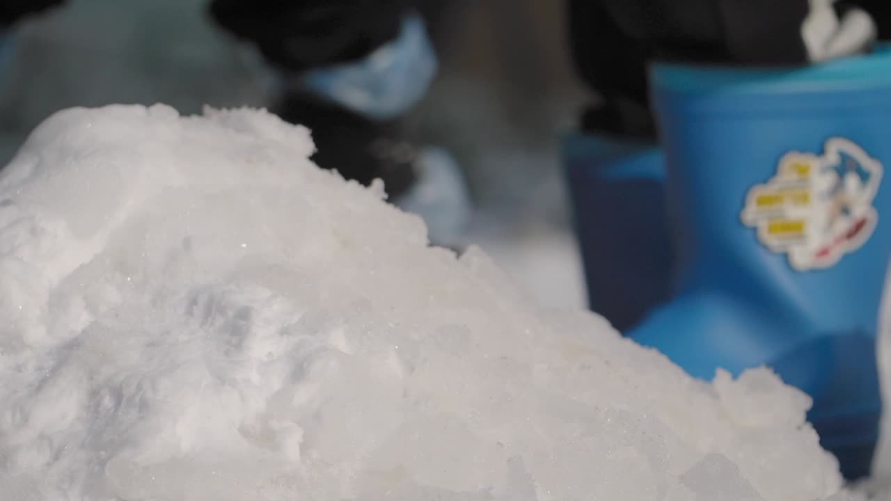 pila de nieve con persona en botas azules