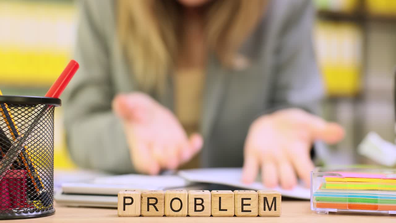 Woman office worker sits at desk and taps irritably on documents