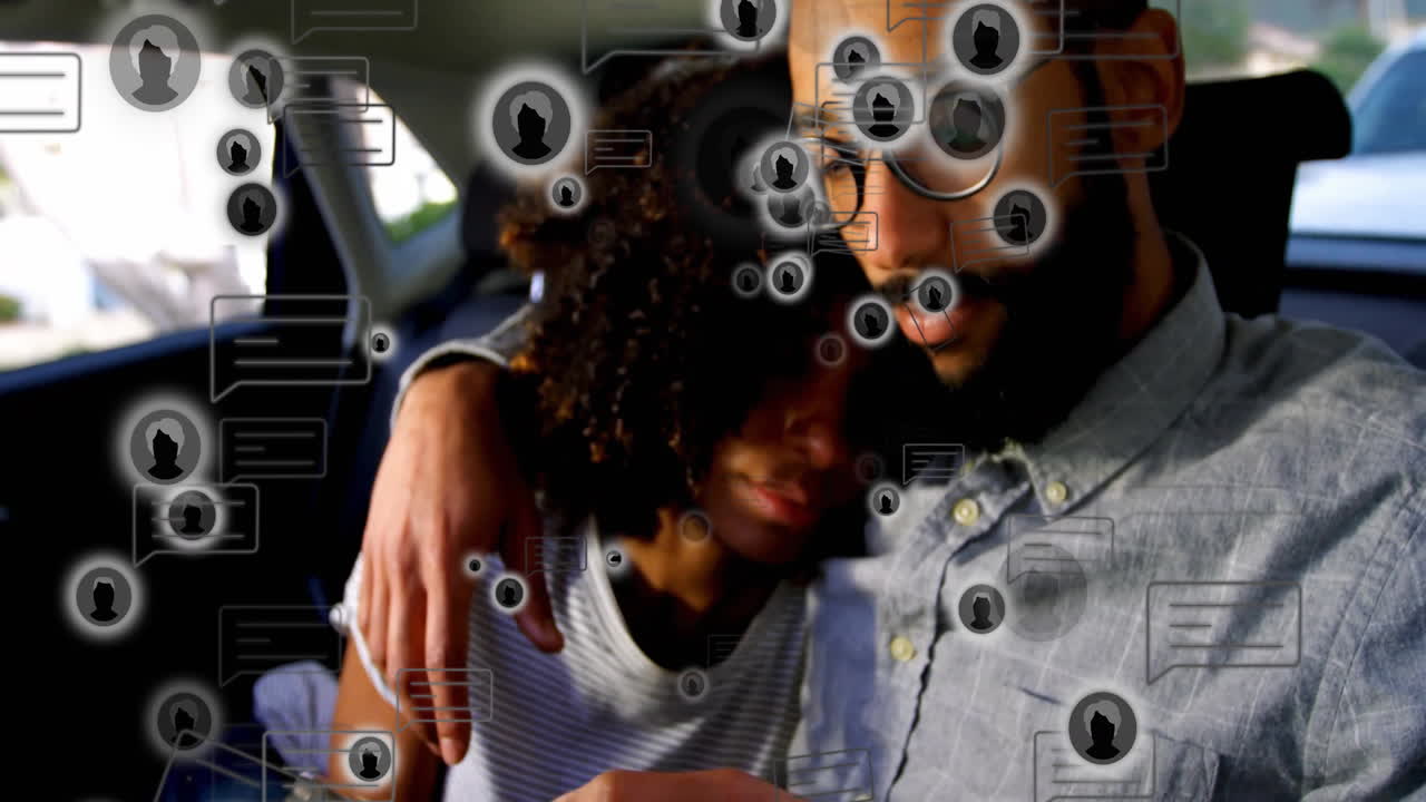 In car, diverse couple interacting with animation of social media icons floating