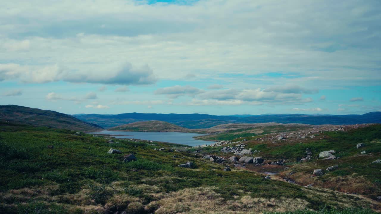 En fredelig utsikt over innsjøen, innrammet av ulendt, kupert terreng, langs reisen fra iMefjelsvatnet til Gurben i Indre Fosen, Trøndelag, Norge – håndholdt opptak