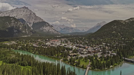 Banff,-AB,-Kanada,-Luftaufnahme-Einer-V34-Drohne-über-Einem-Bewaldeten-Tal-über-Dem-Bow-River-Und-Dem-Stadtzentrum,-Wobei-Im-Sommer-Das-Malerische-Stadtbild-Und-Die-Kaskadengebirge-Eingefangen-Werden-–-Aufgenommen-Mit-Mavic-3-Pro-Cine-–-Juli-2023