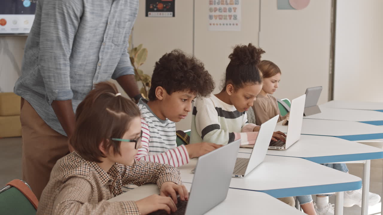 el maestro ayudando a los escolares en la clase