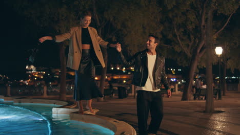 stylish lovers enjoying date walking evening city. playful happy girl stepping