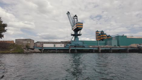 Port-Crane-At-The-Industrial-Facility-Along-The-River-In-Biesbosch-National-Park-Seen-From-Sailing-Boat-In-Netherlands