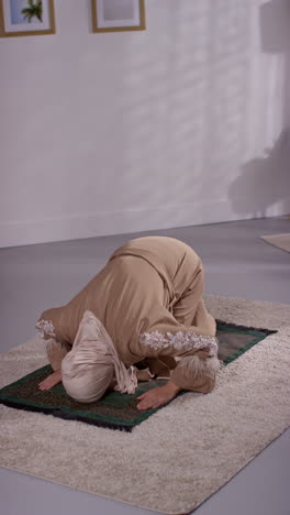 Vertical-Video-Of-Muslim-Woman-Wearing-Hijab-At-Home-Praying-Kneeling-On-Prayer-Mat-5