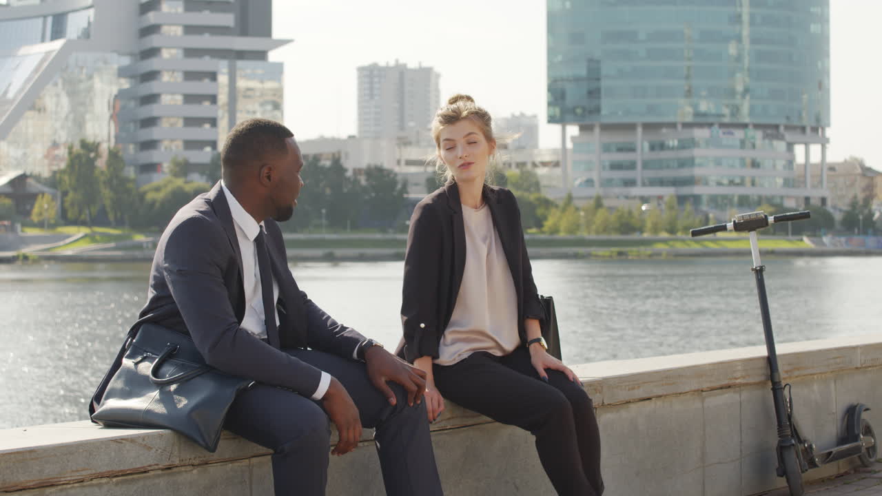 Smart Multiethnic Couple Chatting Near River