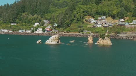 4k-Aerial-rocks-in-the-water-with-coastal-road-in-background