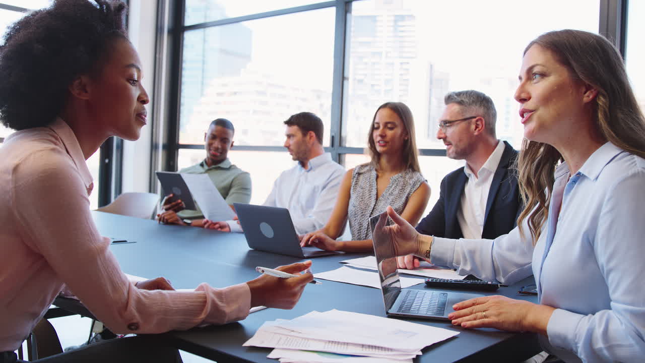 Multi-Cultural Business Team Meeting Around Office Boardroom Table With ...