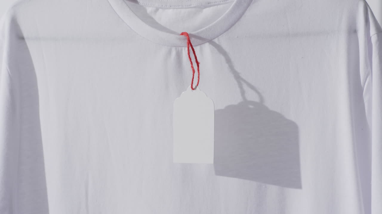 Video of white t shirt with tag and copy space on white background