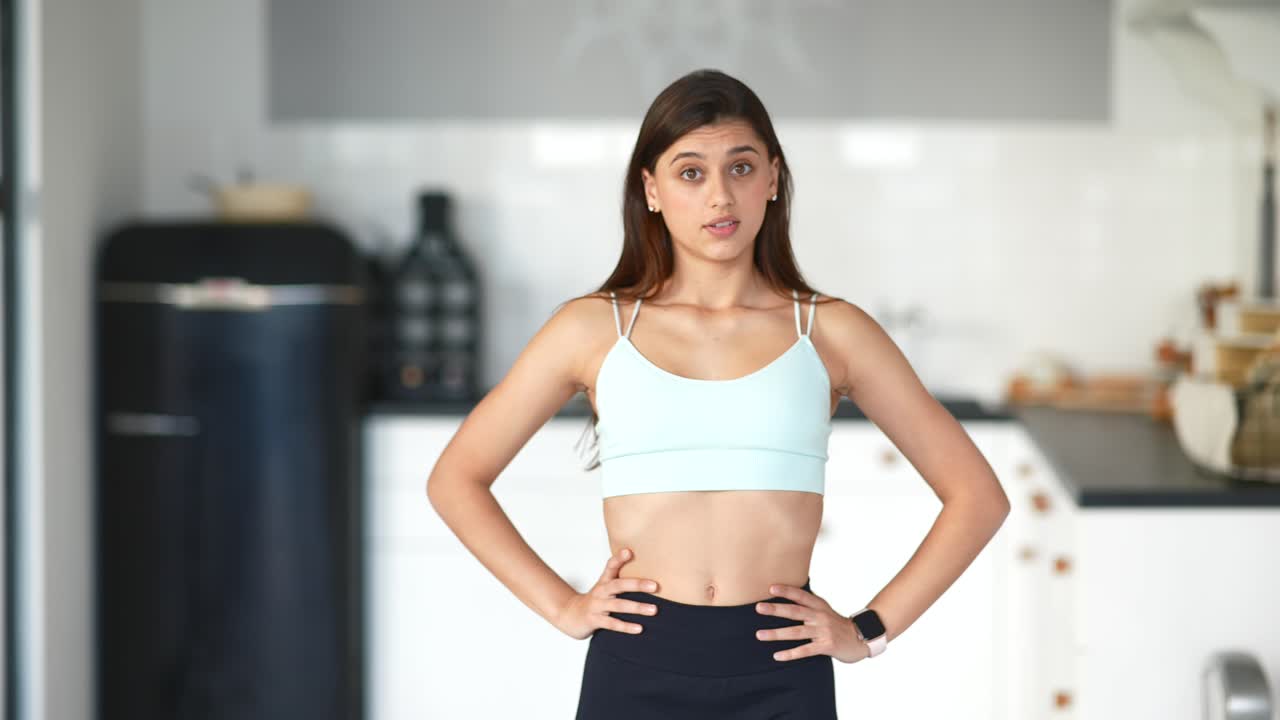mujer joven en traje de entrenamiento en una cocina