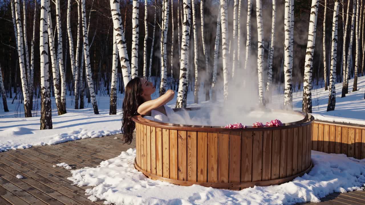 는 핫에서 휴식을 취하는 여성은 눈 인 버드나무와 함께 평온한 겨울 풍경을 즐기며 조용한 건강과 평화로운 겨울 피난처를 구현합니다.