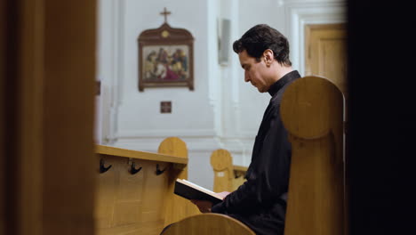 sacerdote sentado en un banco en el interior