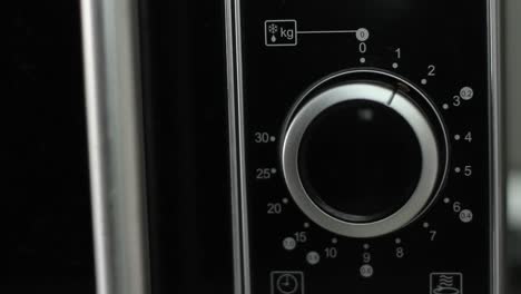 setting microwave timer to one minute and turning microwave off - close up shot - front view