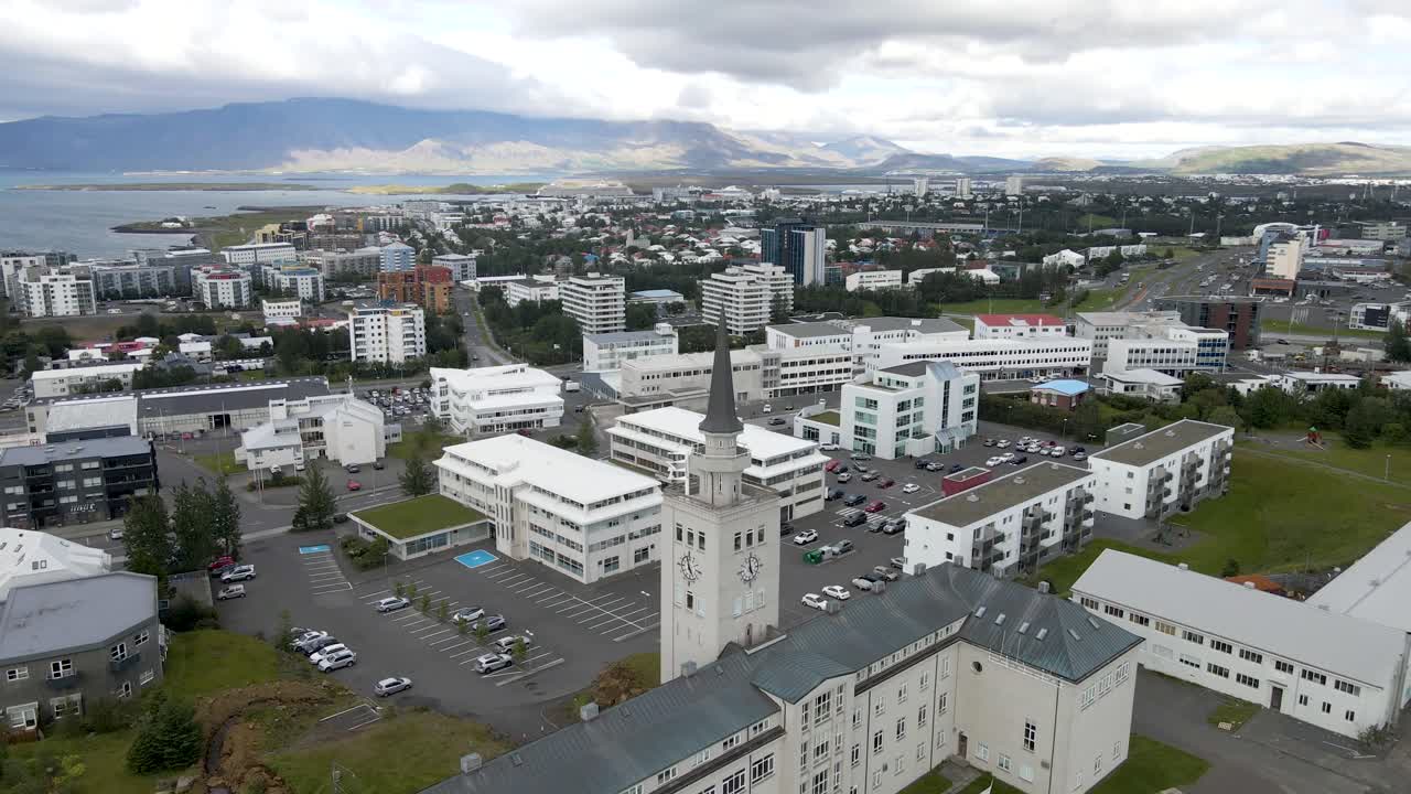 4K drone glide over Reykjavik's heart, with the grand bell tower standing sentinel, backed by the serene waterfront