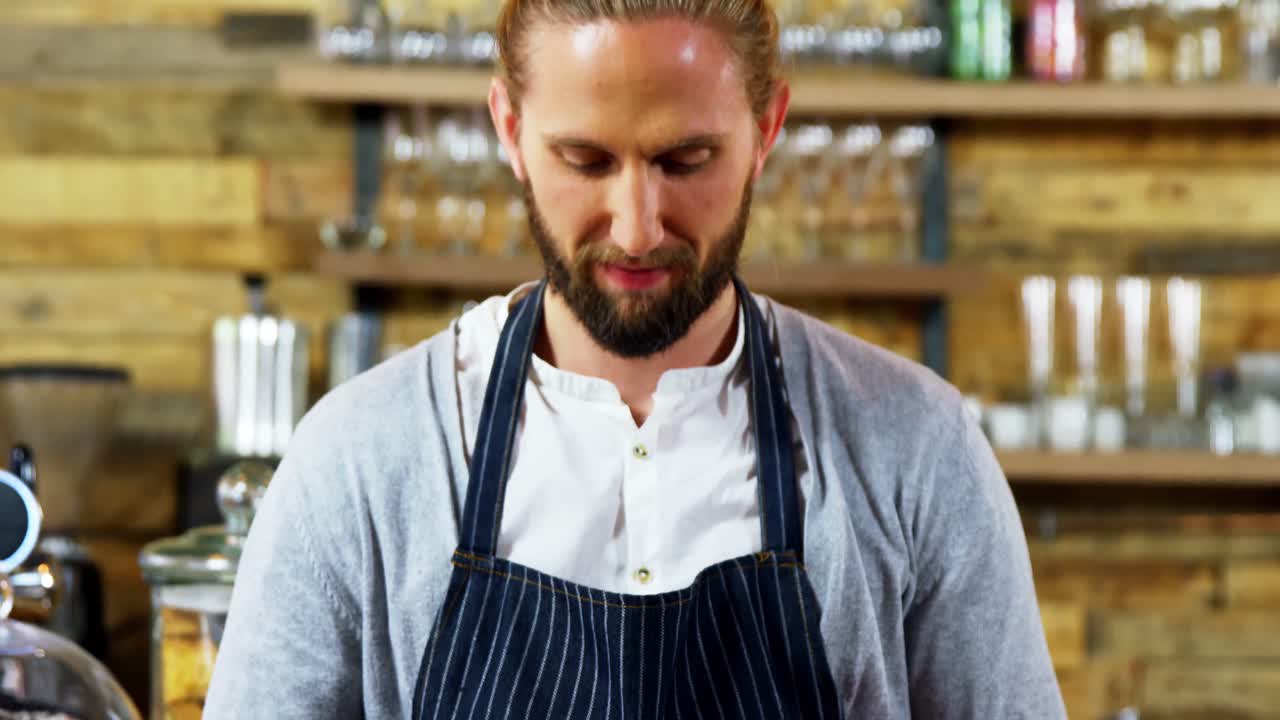 Smilende servitør holder kaffekopp