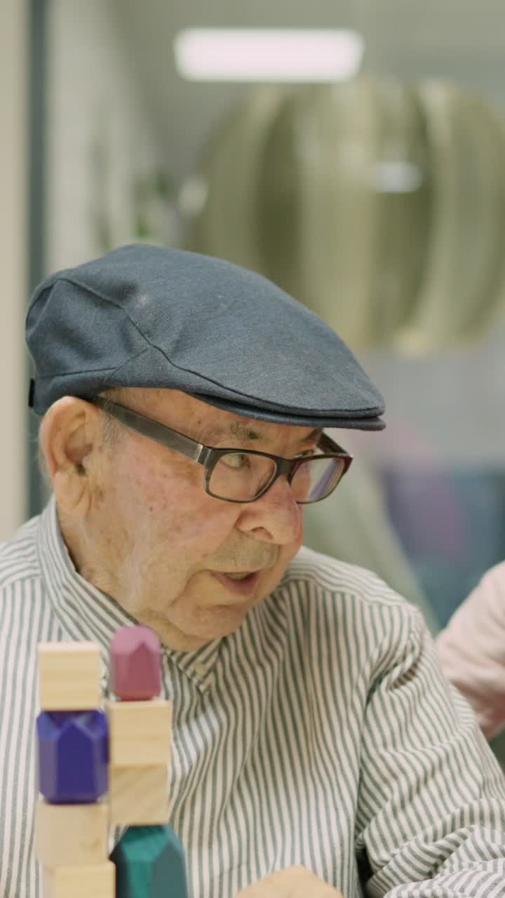 Young woman assisting senior man with building blocks