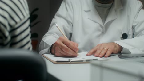 doctor writing notes during a consultation