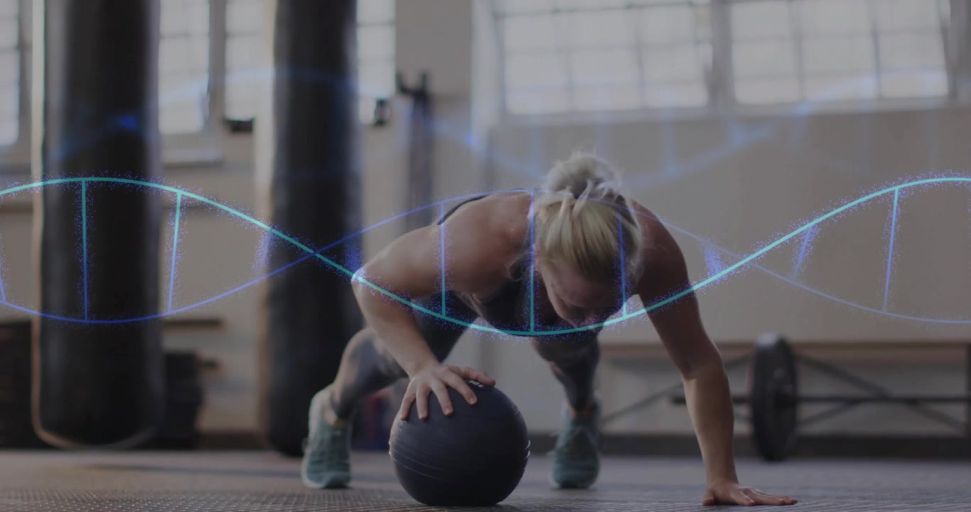Un'atleta donna inizia a fare flessioni, abbassando il petto su una palla zavorrata, mentre mostra dati a onda in palestra.