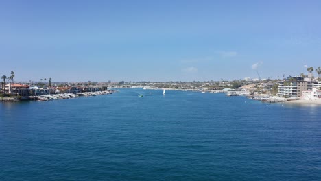 drone-flight-over-bay-channel-to-Newport-harbor-and-Balboa-island,-in-Orange-county,-CA,-USA