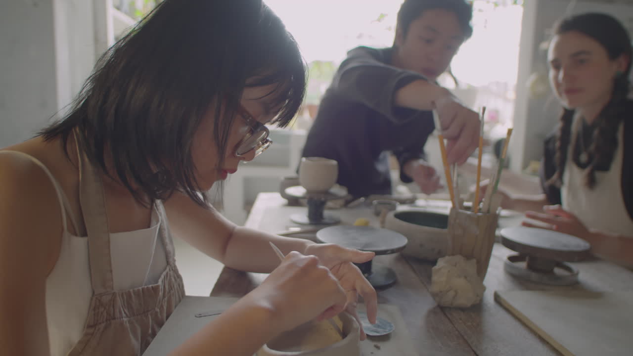 Asian Woman Making Ceramics at Pottery Group Class