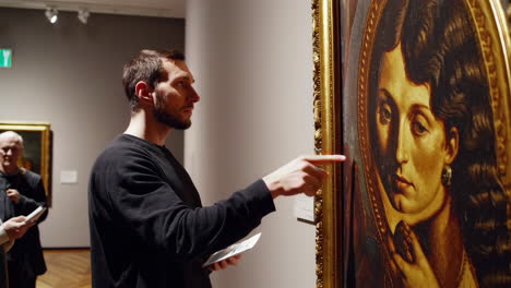 museum visitor looking at a portrait