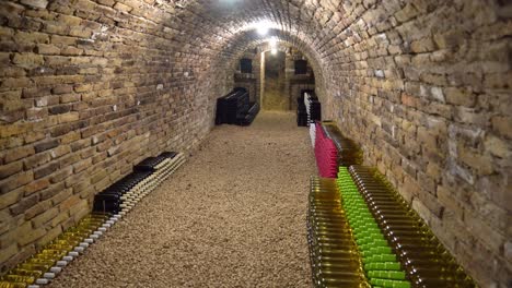 cellar showcase vintage wine bottles in rustic brick storage hole illuminated