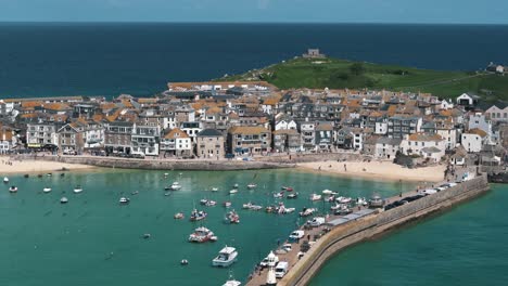 ascending pan down aerial of turquoise st ives bay with boats floating at high tide