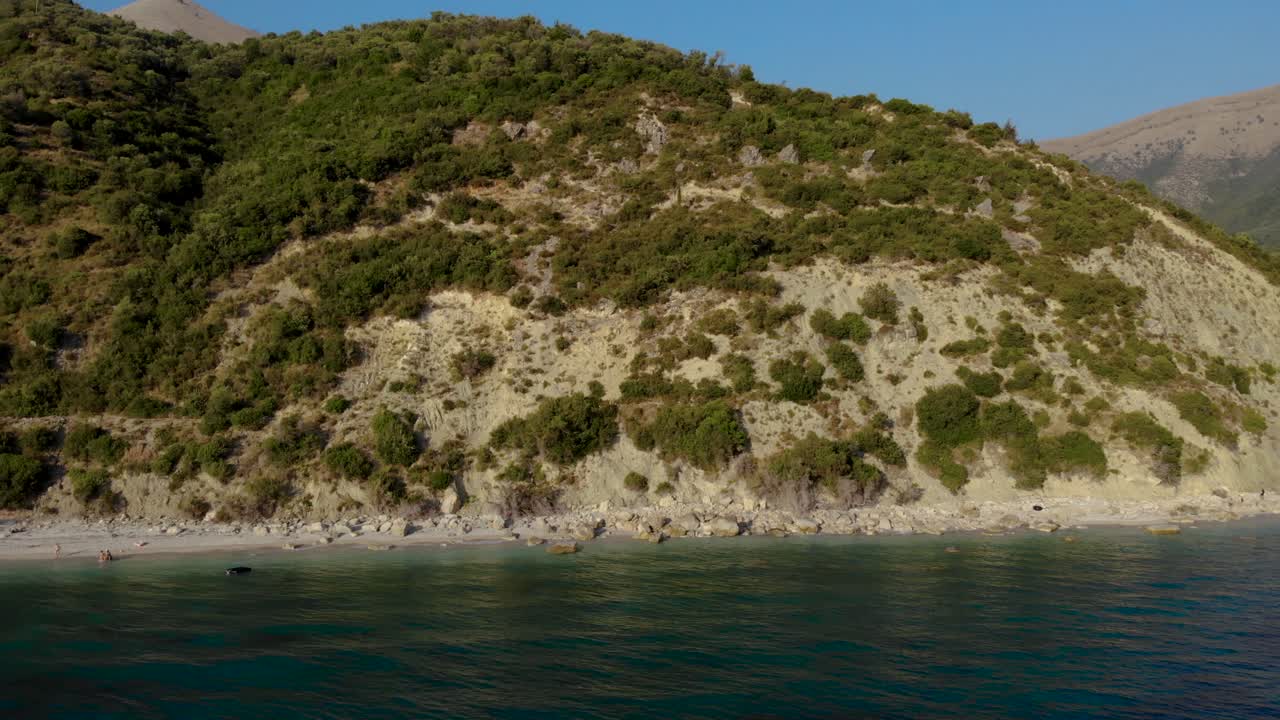 Coastline of Ionian sea with blue azure water washing rocky slopes of mountains in Albania
