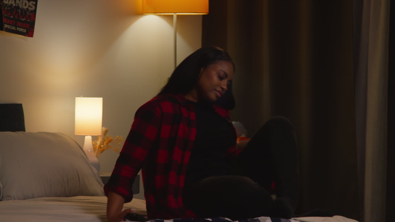 밤에 침실에서 스마트폰을 사용하는 여성