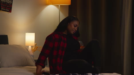 Woman using smartphone in bedroom at night