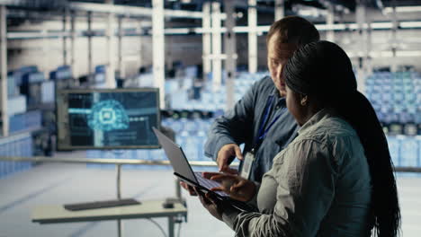 server room coworkers use laptop to install updates and keep ai systems running