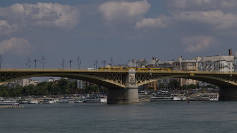 budapest margit bridge over danube, tram train and cars driving on top